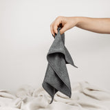 Magic Towel: Von einer Hand gehalten, präsentiert auf neutralem Hintergrund mit einer weißen Decke. Ein vielseitiges und sanftes Reinigungstuch, hervorragend für empfindliche Oberflächen und eine effektive Schmutz- und Feuchtigkeitsaufnahme.