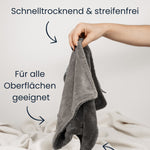 Das Dry Towel von LUFIP wird von einer Hand gehalten, vor neutralem Hintergrund. Textbeschriftungen auf dem Bild heben die Eigenschaften hervor: „Schnelltrocknend & streifenfrei“, „Für alle Oberflächen geeignet“ und „Langlebig und wiederverwendbar“. Das Tuch liegt auf einem hellen Stoffuntergrund.
