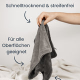Das Dry Towel von LUFIP wird von einer Hand gehalten, vor neutralem Hintergrund. Textbeschriftungen auf dem Bild heben die Eigenschaften hervor: „Schnelltrocknend & streifenfrei“, „Für alle Oberflächen geeignet“ und „Langlebig und wiederverwendbar“. Das Tuch liegt auf einem hellen Stoffuntergrund.