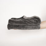 Ein Stapel aus zwei Dry Towels von LUFIP wird auf einer ausgestreckten Hand präsentiert. Der neutrale Hintergrund betont die kompakte Größe und die weiche, saugfähige Textur des Produkts. Perfekt für effizientes und müheloses Trocknen.
