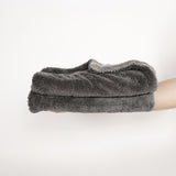 Ein Stapel aus zwei Dry Towels von LUFIP wird auf einer ausgestreckten Hand präsentiert. Der neutrale Hintergrund betont die kompakte Größe und die weiche, saugfähige Textur des Produkts. Perfekt für effizientes und müheloses Trocknen.
