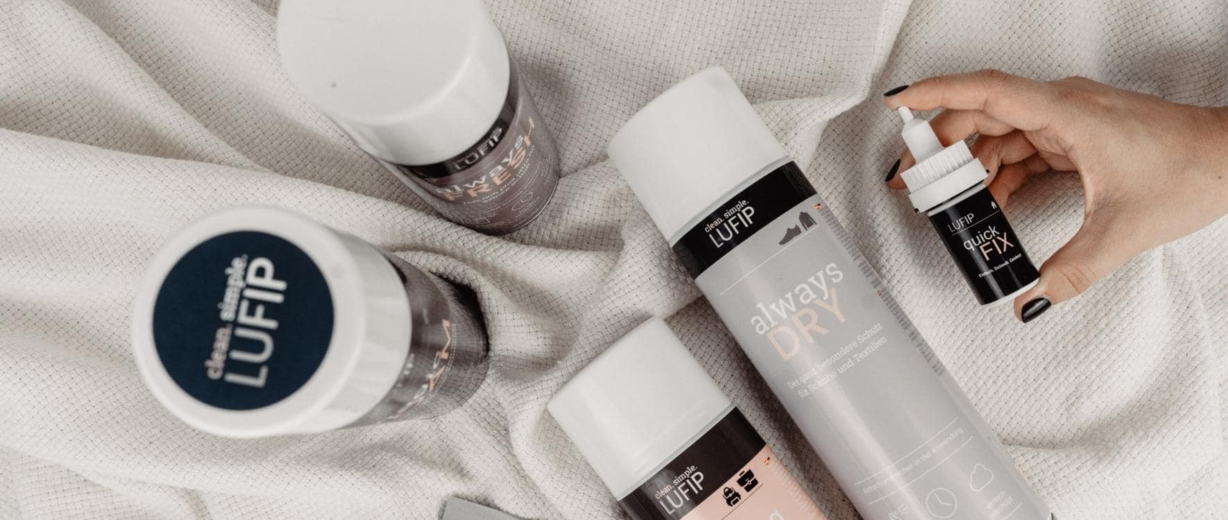 Überblick über das Sortiment von Lufip-Produkten auf einer weißen Decke. Eine Vielfalt an Reinigungsprodukten, präsentiert in stilvollem Arrangement, umfasst Magic Foam, Quick Fix, Always Dry, Always Fresh, Bag Refresh und weitere hochwertige Reinigungslösungen.