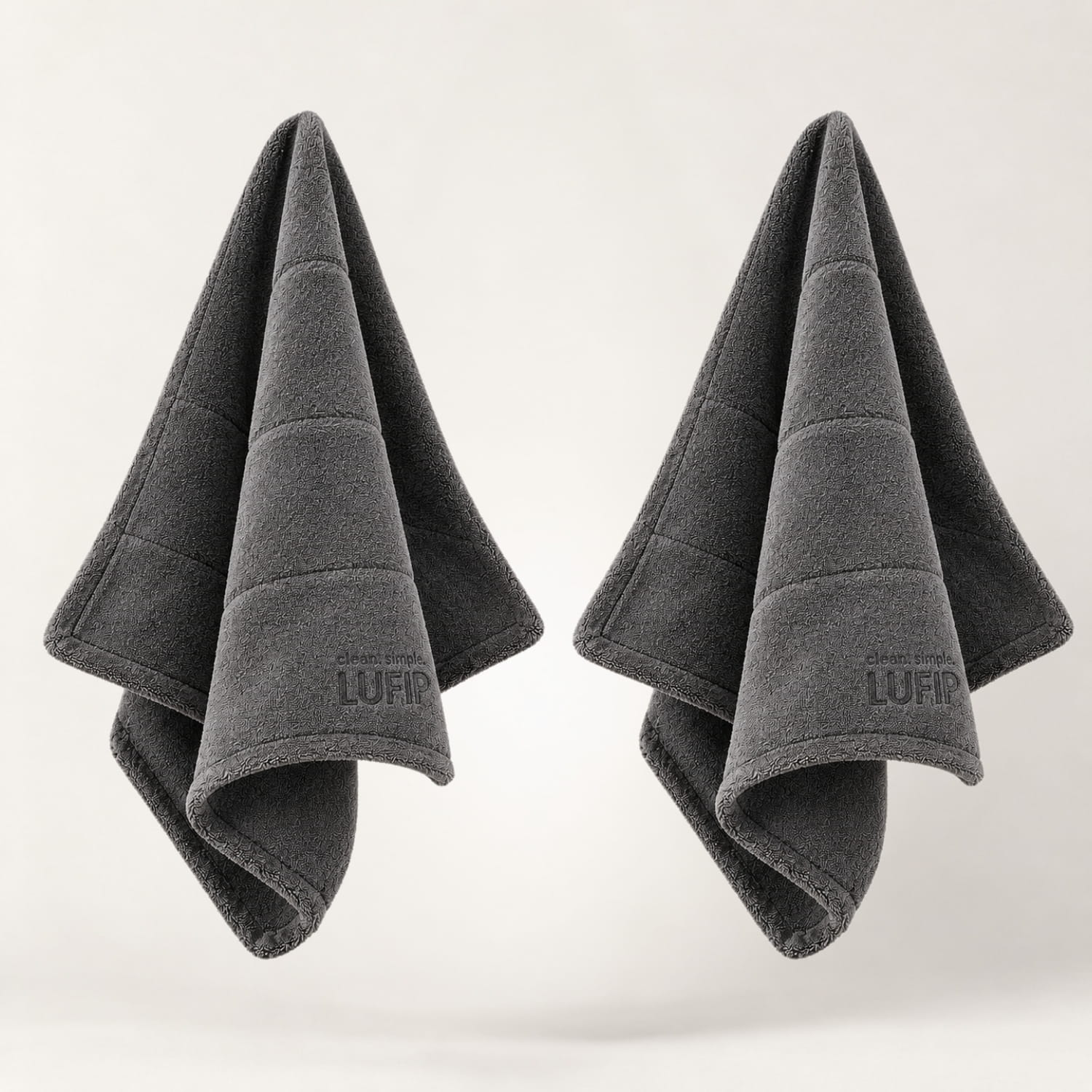 Zwei dunkelgraue LUFIP Ultra Towels mit dichter Twist-Struktur für starke Wasseraufnahme und streifenfreies Trocknen.