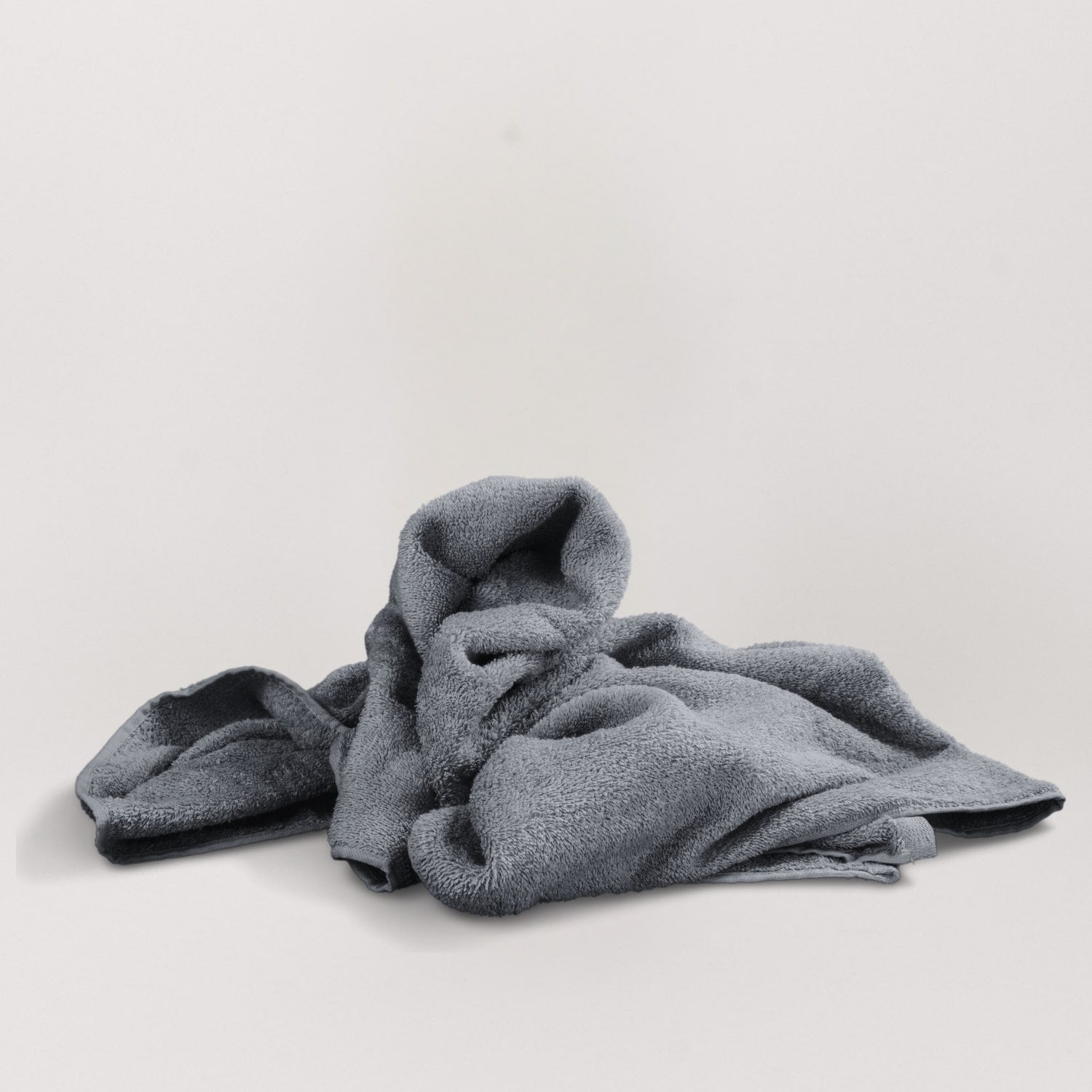 Magic Towel: Von einer Hand gehalten, präsentiert auf neutralem Hintergrund mit einer weißen Decke. Ein vielseitiges und sanftes Reinigungstuch, hervorragend für empfindliche Oberflächen und eine effektive Schmutz- und Feuchtigkeitsaufnahme.