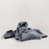 Magic Towel: Von einer Hand gehalten, präsentiert auf neutralem Hintergrund mit einer weißen Decke. Ein vielseitiges und sanftes Reinigungstuch, hervorragend für empfindliche Oberflächen und eine effektive Schmutz- und Feuchtigkeitsaufnahme.